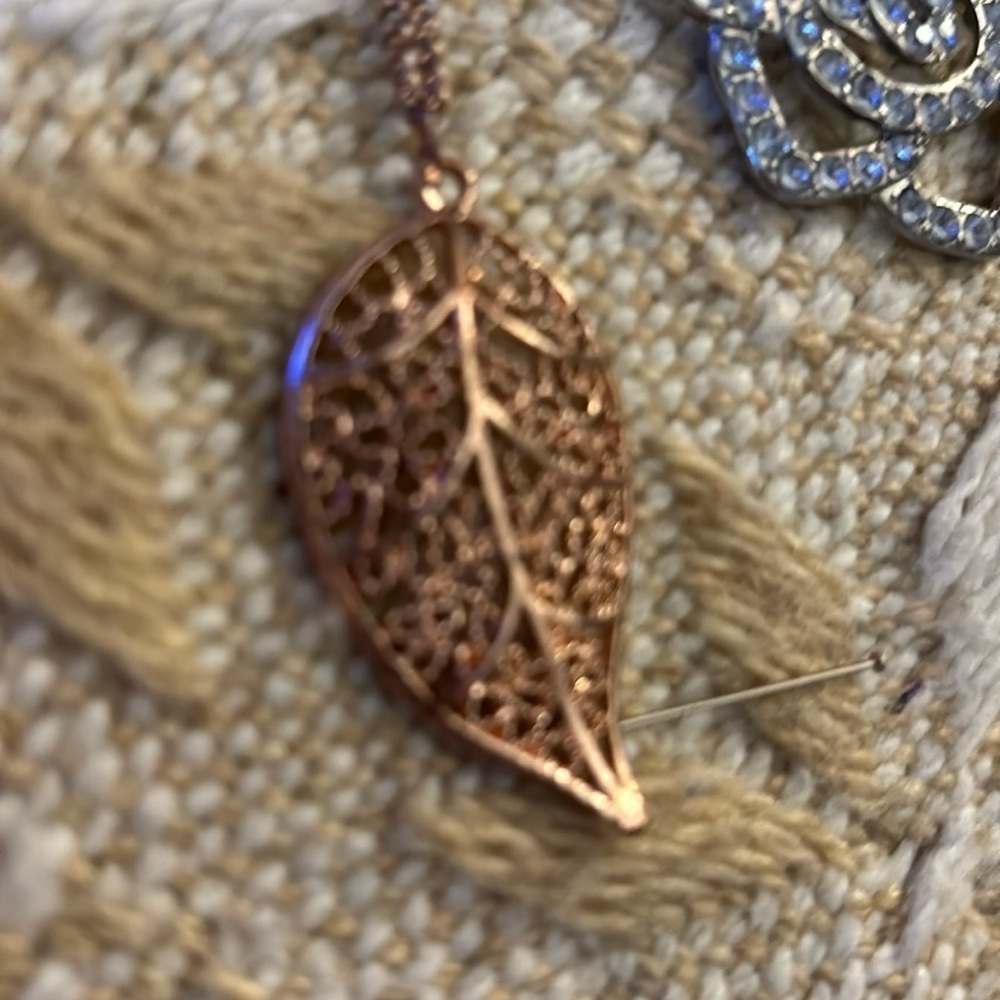 Gold chain with gold leaf pendant.. reaches mid chest